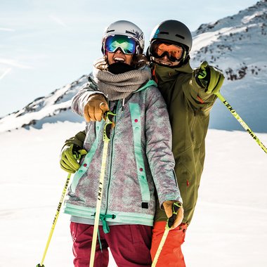 Zwei Skifahrer vor Bergpanorama